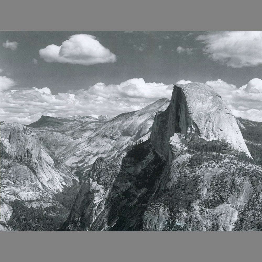 Black and white photo of Half Dome in Yosemite under large clouds